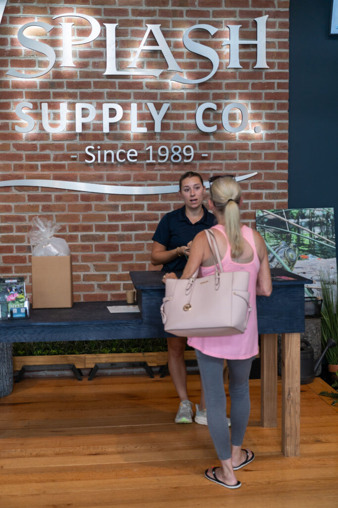 A customer talking with a Splash Supply employee in the lobby of their retail store.